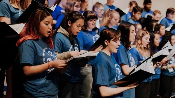 Schüler der J.V. Humphries Secondary School stehen in blauen Hemden und singen gemeinsam im Chor.