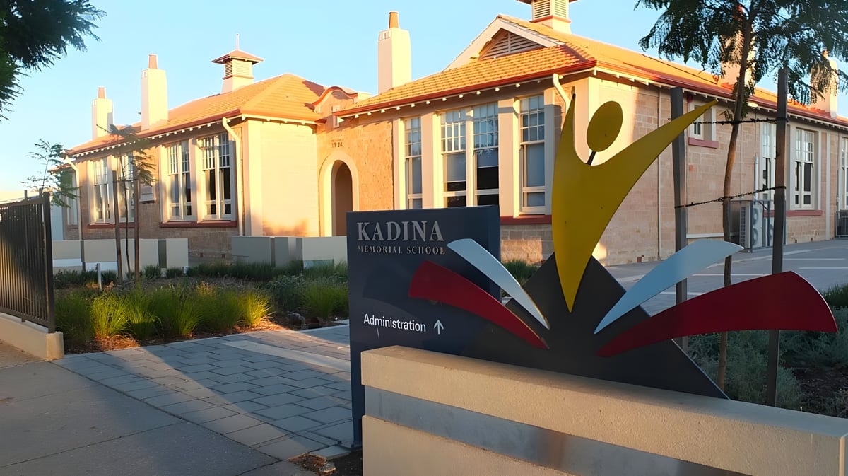 Das farbenfrohe und verzierte Gebäude der Kadina Memorial School ist von Palmen umgeben und steht neben einem gepflasterten Weg.