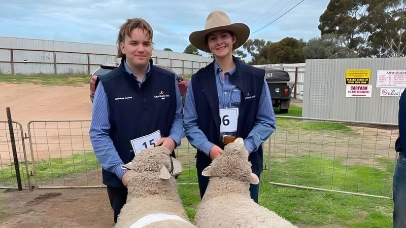 Zwei Personen mit Cowboyhüten stehen im umzäunten Außenbereich der Kadina Memorial School.
