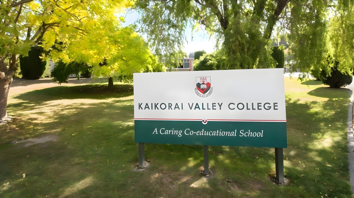 Das Schild des Kaikorai Valley College steht umgeben von gelb belaubten Bäumen in einer parkähnlichen Umgebung.