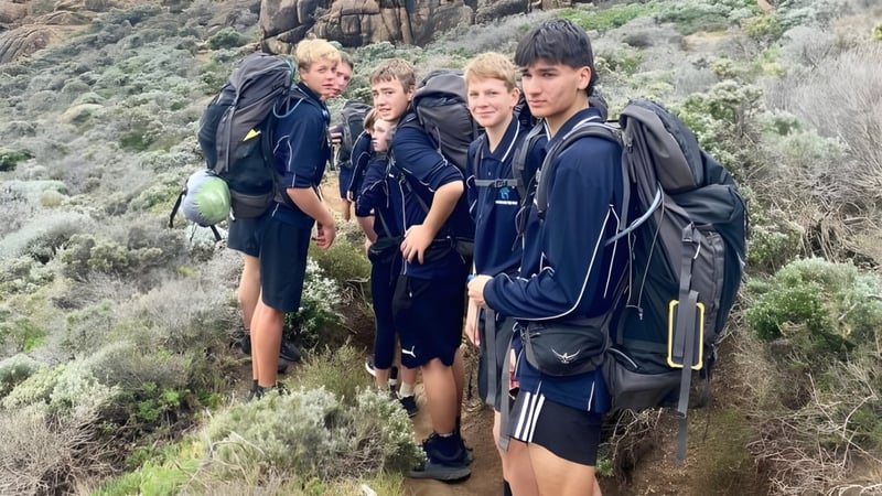 Schüler der Kalamunda Senior High School stehen auf einem felsigen Gebirgspfad umgeben von dichter Vegetation.