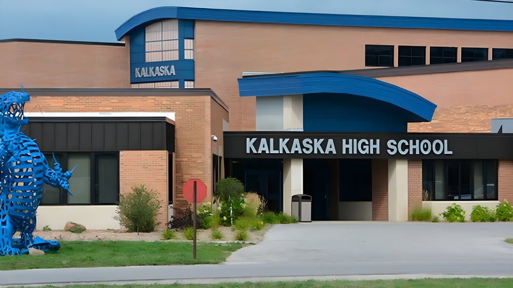 Das moderne Backsteingebäude mit blauen Akzenten und dem Schriftzug Kalkaska High School am Haupteingang.
