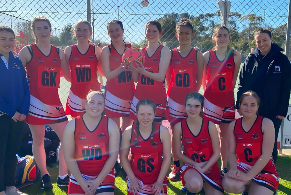 Eine Gruppe junger Athletinnen in roten und weißen Uniformen auf dem Sportfeld der Kangaroo Island Community Education.