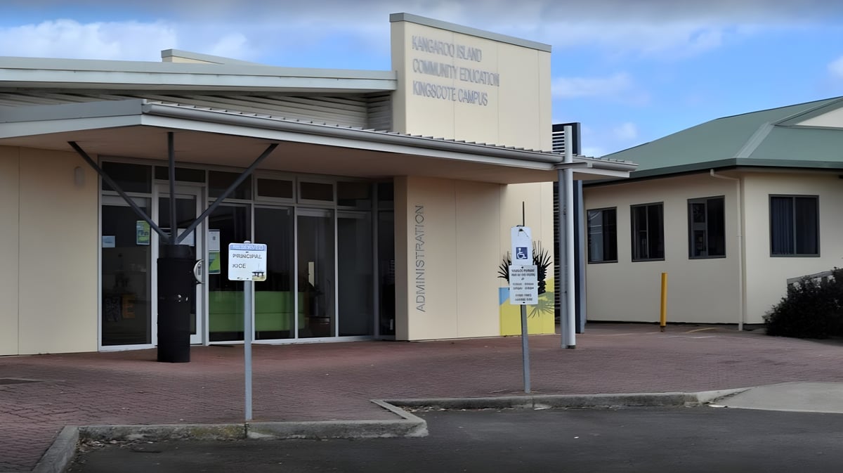 Das moderne Gebäude mit Glasfassade auf dem Gelände der Kangaroo Island Community Education ist von einem gepflasterten Bereich umgeben.
