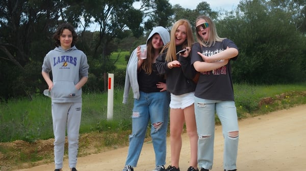 Vier Schülerinnen stehen zusammen in einer natürlichen Umgebung mit Bäumen auf dem Gelände der Kapunda High School.