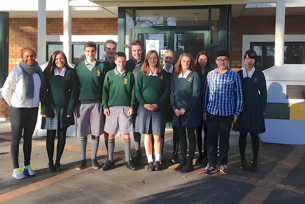 Eine Gruppe Schüler steht vor dem Ziegelgebäude des Katikati College mit einem gläsernen Eingang.