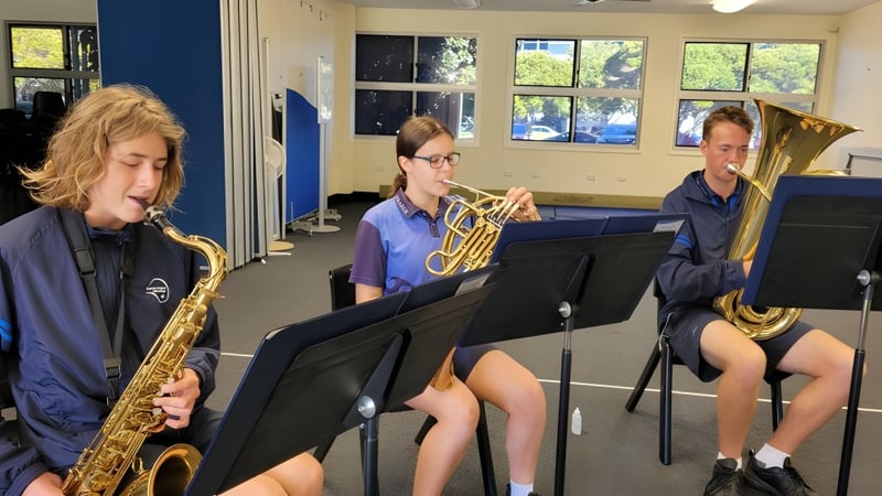 Schüler der Kawana Waters State College spielen in einem Musikraum Instrumente wie Saxophon, Posaune und Tuba.