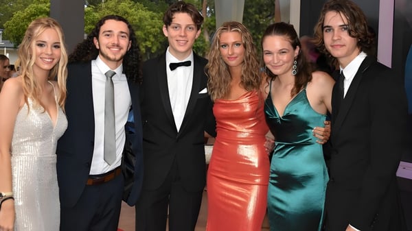 Eine Gruppe gut gekleideter Schülerinnen und Schüler posiert auf einem roten Teppich beim Event am Kawana Waters State College.