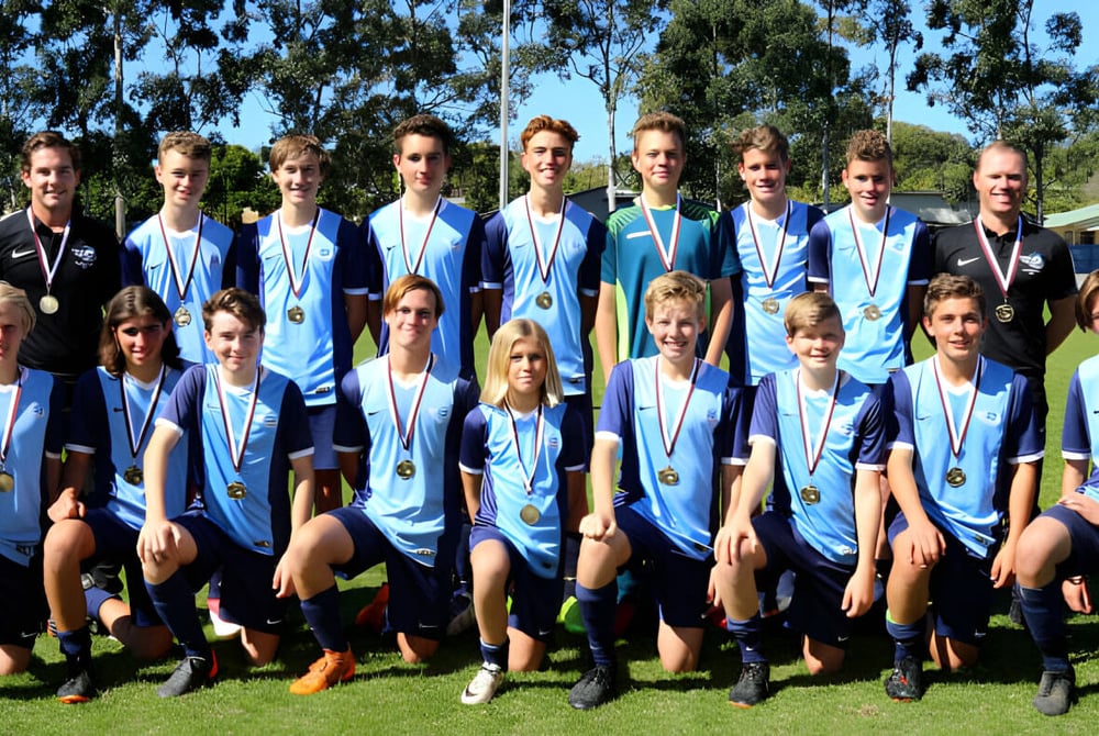 Eine Gruppe von Schülern spielt Fußball auf dem Spielfeld des Kawana Waters State College.