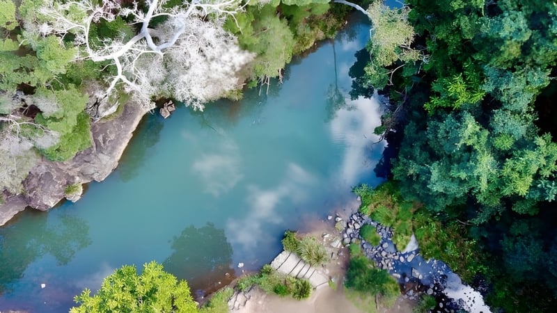 Ein ruhiger Fluss fließt durch eine grüne Landschaft nahe der Kedron State High School.