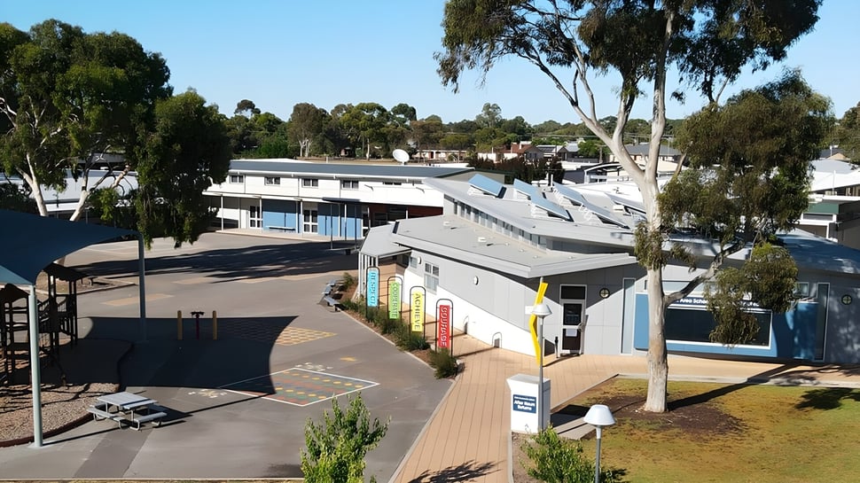 Das moderne mehrstöckige Gebäude mit farbigen Fassaden der Keith Area School ist von Bäumen und Grünflächen umgeben.