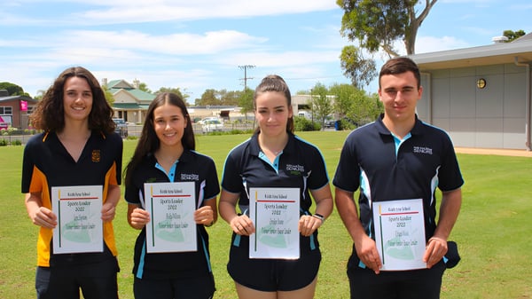 Vier Schülerinnen und Schüler der Keith Area School stehen auf einer Wiese und halten Urkunden in den Händen.