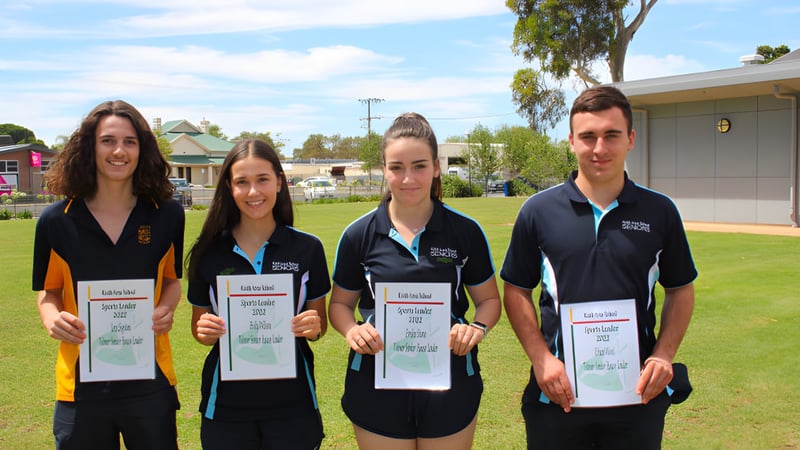 Vier Schülerinnen und Schüler der Keith Area School stehen auf einer Wiese und halten Urkunden in den Händen.