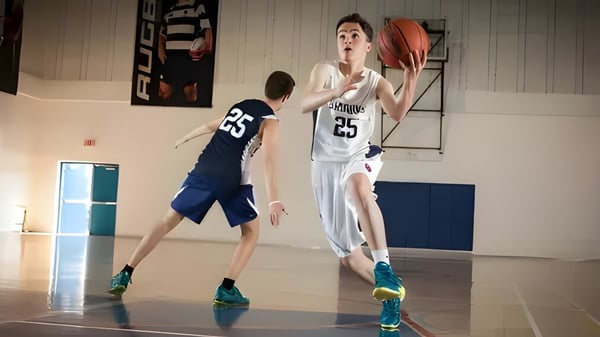 Zwei Schüler der Kells Academy spielen auf dem Basketballfeld gegeneinander.