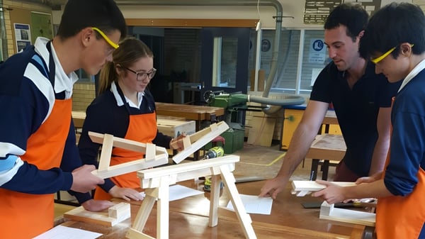 Schüler der Kelvin High School arbeiten gemeinsam an einem Holzprojekt in der Werkstatt.