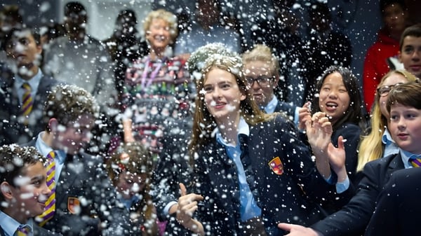 Schüler der Kensington Park School feiern gemeinsam mit fallendem Konfetti.