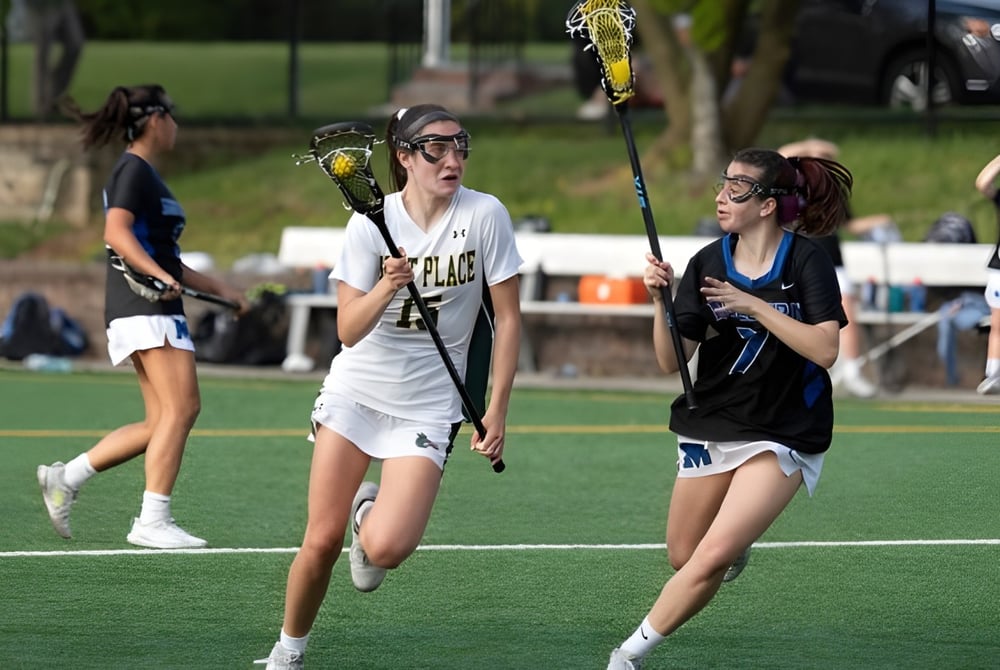 Zwei Spielerinnen der Kent Place School treten auf dem Spielfeld in einem Lacrosse-Spiel gegeneinander an.