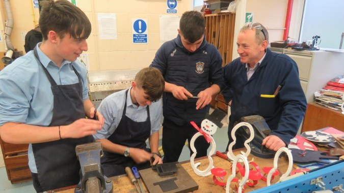 Schüler und Lehrkräfte der Kilkenny City Vocational School arbeiten gemeinsam an einem Projekt in einem Klassenraum.
