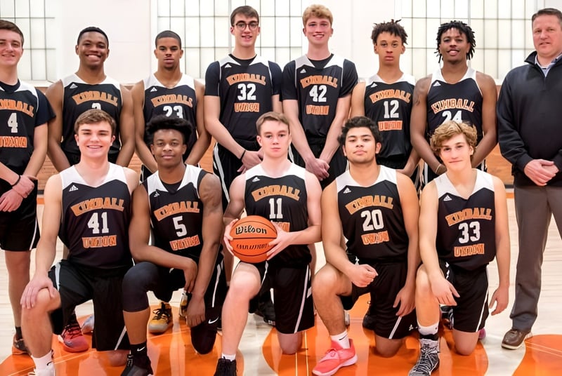 Eine Gruppe junger Basketballspielerinnen und Basketballspieler posiert in der Sporthalle der Kimball Union Academy.