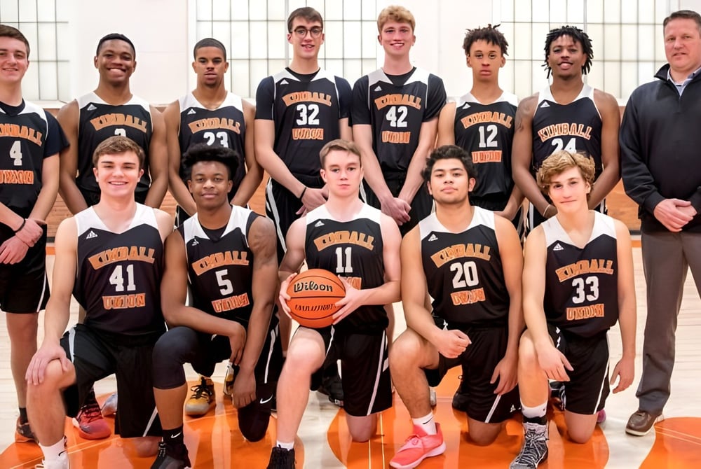 Eine Gruppe junger Basketballspielerinnen und Basketballspieler posiert in der Sporthalle der Kimball Union Academy.