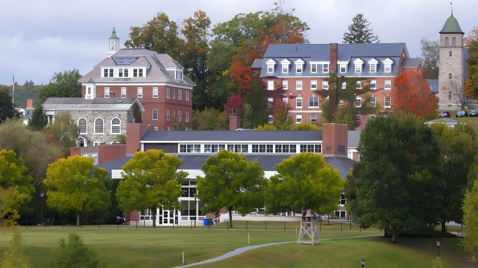 Der Campus der Kimball Union Academy zeigt historische und moderne Gebäude umgeben von buntem Herbstlaub unter bewölktem Himmel.