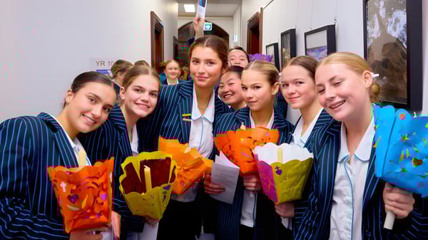 Schülerinnen der Kincoppal-Rose Bay stehen im Flur mit bunten Blumensträußen in der Hand.