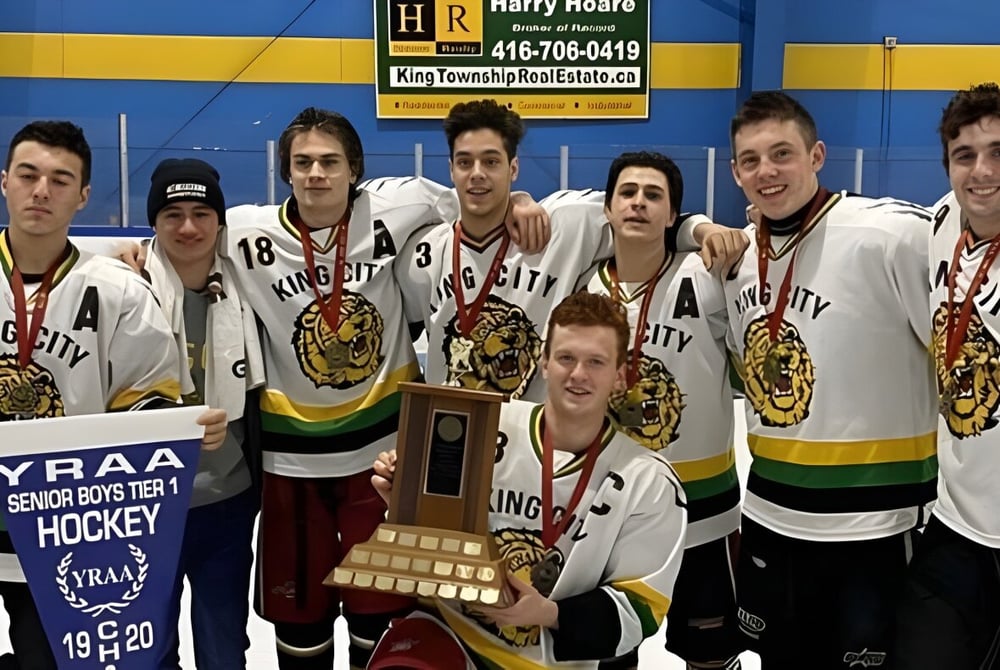 Schüler der King City Secondary School posieren mit Pokalen vor blau-gelbem Hintergrund nach einem Hockeyspiel.
