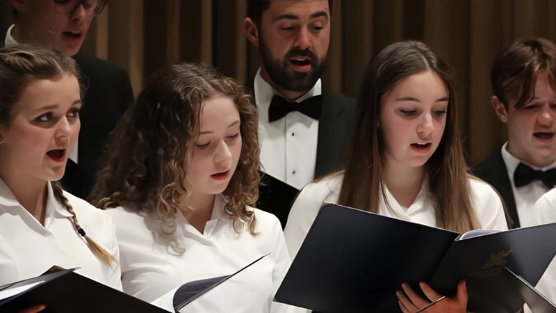 Eine Gruppe Schülerinnen und Schüler des King's Bruton singt gemeinsam bei einem Auftritt auf der Bühne.