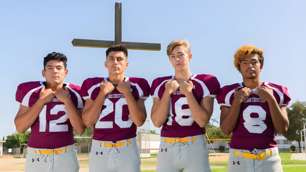 Vier Schüler der Kings Christian School stehen vor einem großen Kreuz im Freien.