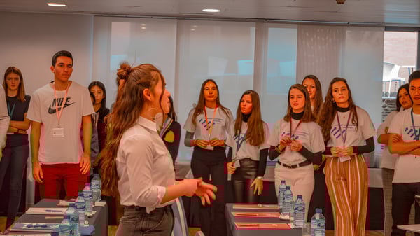 Eine Gruppe Schülerinnen und Schüler des King’s College versammelt sich in einem Veranstaltungsraum mit einer Rednerin im Vordergrund.