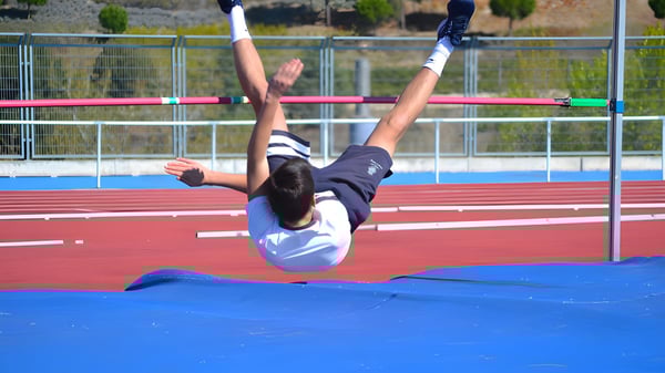 Eine Schülerin des King's College führt einen Hochsprung auf der Sportanlage durch.