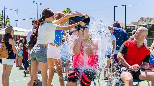 Schüler der King's College spielen und planschen gemeinsam im Wasser auf dem Außenbereich der Schule.