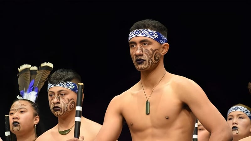 Eine Gruppe von Männern mit traditionellen Maori-Gesichtstattoos und Kopfschmuck präsentiert eine Tanzaufführung auf der Bühne der King's High School.
