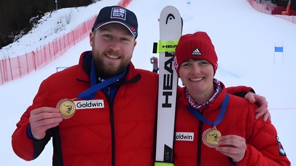 Zwei Personen der King's School zeigen auf einer Winterveranstaltung stolz ihre Goldmedaillen.