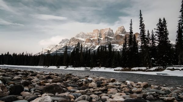 Verschneite Winterlandschaft mit Flussbett und Bergen nahe der Kingston Secondary School.