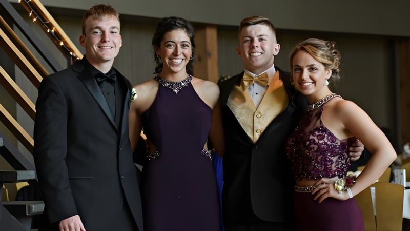 Vier formell gekleidete Personen stehen zusammen in einem dekorativen Raum auf dem Campus der Kingsville District High School.