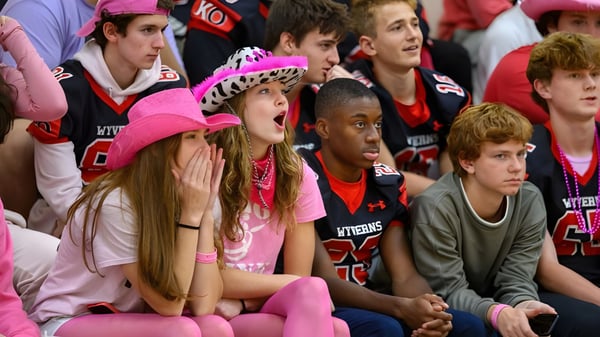 Eine Gruppe von Fans unterstützt aktiv ihr Team bei einer Sportveranstaltung auf dem Campus der Kingswood Oxford.