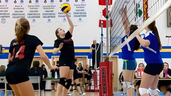 Schülerinnen und Schüler der Kinkora Regional High School spielen Volleyball in der Turnhalle.