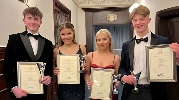 Vier Personen der Kirkham Grammar School halten Auszeichnungen in einem Raum mit prachtvoller Dekoration.