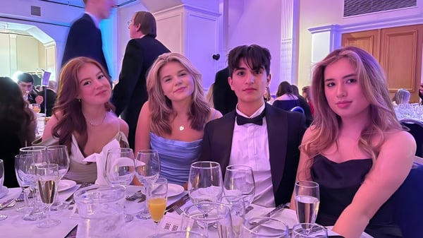 Vier Schülerinnen der Kirkham Grammar School sitzen in formeller Kleidung an einem festlich gedeckten Tisch.