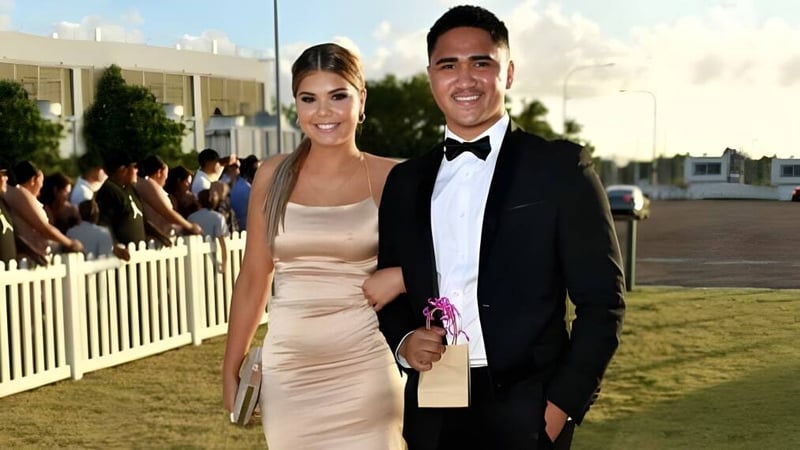 Ein gut gekleidetes Paar steht auf einer Wiese vor einer Menschenmenge auf dem Gelände der Kirwan State High School.