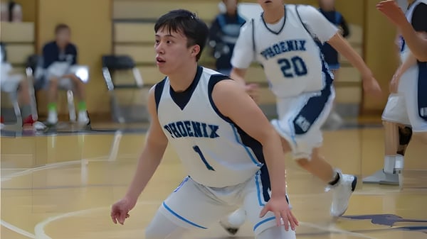 Ein Schüler der Korea International School dribbelt den Basketball während eines Spiels, begleitet von seinen Teamkollegen.