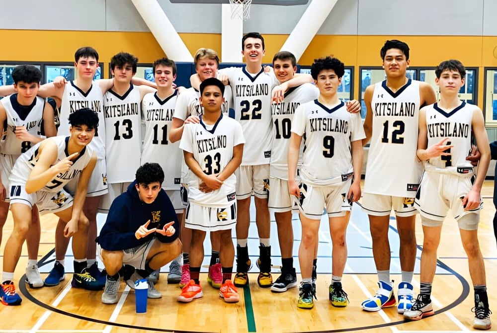 Eine Gruppe von Schülerinnen und Schülern der Kitsilano Secondary School posiert gemeinsam auf dem Basketballplatz mit sichtbarem Korb im Hintergrund.
