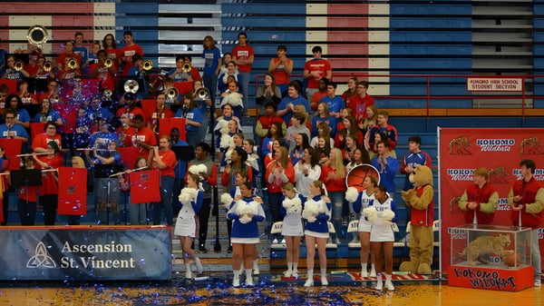 Eine Gruppe von Schülern in roten und blauen Uniformen steht in der Sporthalle der Kokomo-Center Township Consolidated School Corporation.