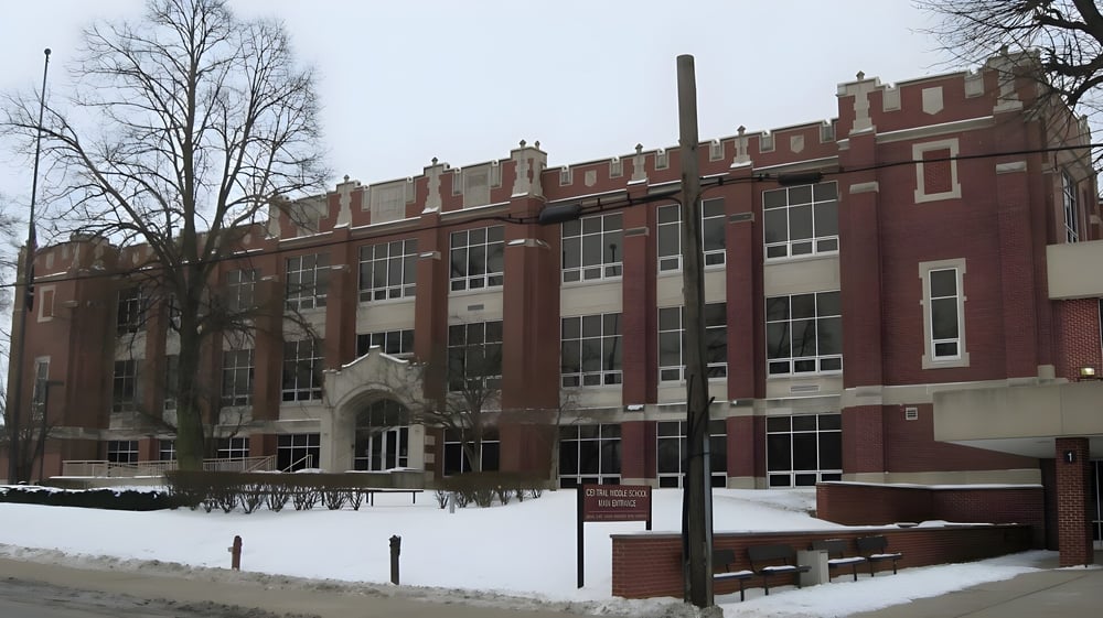 Das große Backsteingebäude der Kokomo-Center Township Consolidated School Corporation ist von schneebedecktem Gelände und kahlen Bäumen umgeben.