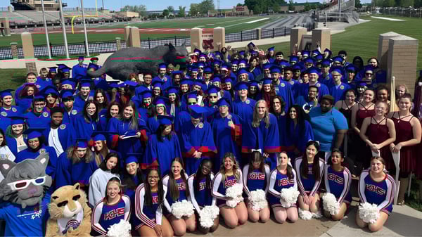Eine Gruppe von Schülerinnen und Schülern der Kokomo-Center Township Consolidated School Corporation steht vor einem Sportstadion.
