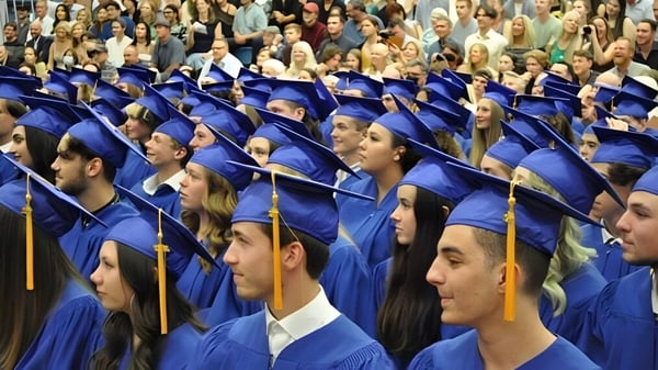 Eine große Gruppe von Absolventinnen und Absolventen in blauen Talaren sitzt bei der Abschlussfeier der Kootenay River Secondary.