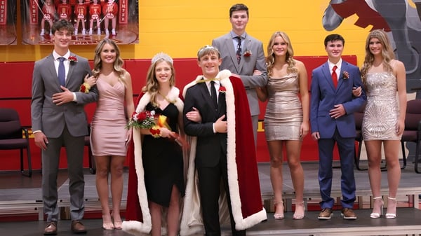 Eine Gruppe festlich gekleideter Personen posiert vor chinesischer Dekoration bei der Kuemper Catholic High School.