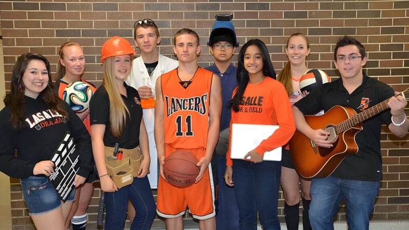 Eine Gruppe von Schülerinnen und Schülern der La Salle Secondary School posiert vor einer Backsteinwand.