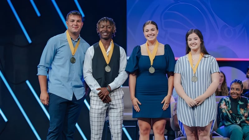 Vier Personen in formeller Kleidung auf der Bühne bei der Lafayette Christian Academy mit Auszeichnungen in der Hand.
